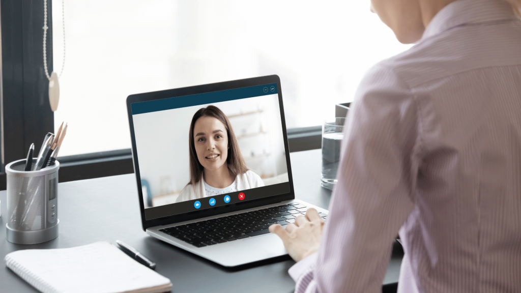Person im Videogespräch mit einem KI-Avatar am Laptop